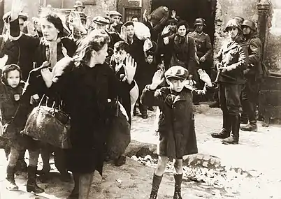 Expulsion de Juifs du ghetto. Photo extraite du rapport de mai 1943 de Jürgen Stroop à Heinrich Himmler, comportant la Légende :  Mit Gewalt aus Bunkern hervorgeholt « Sortis de force de leur abri ». Cette photo est l'une des plus célèbres de la Seconde Guerre mondiale.