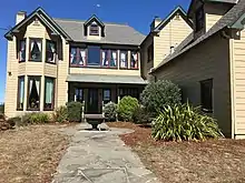 Photo d'une maison avec une sculpture et des arbustes.