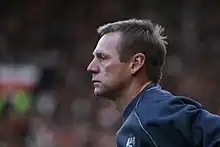 A man facing left, in a football training top