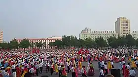 Étudiants dansant lors du 69e anniversaire de la création de la RPDC (en 2017) à l'extérieur du stade Pyongyang Arena.