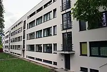 immeuble de 4 étages, quatre cages d’escaliers avec des fenêtres en façade séparent les appartements.