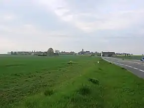 vue générale d'un village de plaine dominé par le clocher de l'église