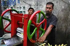 Jus de canne par un vendeur de boisson de rue, Dacca, Bangladesh.