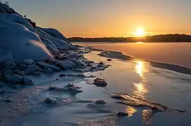 Soleil couchant se reflétant sur la glace du Brofjorden. Janvier 2021.