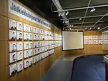 Photographie d'un mur où les membres du Temple de la renommée du hockey finlandais y sont présentés.
