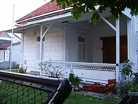 Vue de l'entrée d'une maison aux murs blancs avec une terrasse