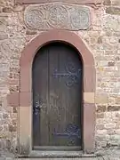 Porte latérale avec linteau roman.