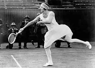 Photographie en noir et blanc de Suzanne Lenglen en pleine séquence de jeu à Wimbledon