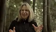 Portrait de Suzanne Simard avec une forêt en fond