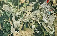 Photo satellitaire du circuit de Suzuka et des alentours, avec notamment des champs et des forêts en bas, et une ville en haut à droite.