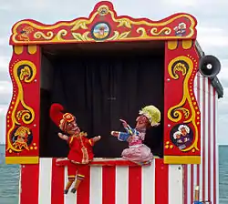 Théâtre ressemblant à celui de Guignol, bariolé, avec marionnettes sur la scène