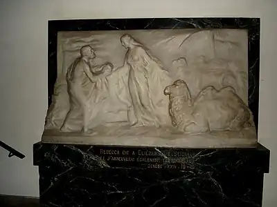 Bas-relief de Rebecca donnant à boire à Éliézer et à ses chameaux. Ce bas-relief, représentant des figures humaines, se trouve dans un vestibule à l’entrée de la synagogue.