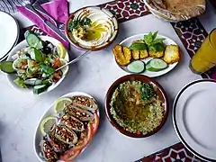 mezzé syrien : makdous, salade syrienne, houmous, halloumi et baba ganousch, avec du pain pita
