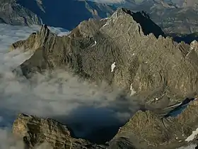 Vue aérienne de la Tête à Pierre Grept depuis le sud-ouest avec la petite ligne de crête s'en éloignant vers la gauche et où se trouvent la Pierre qu'Abotse (pic rocheux), le Gros Sex (à ses pieds devant lui) et le Sex des Branlettes derrière la Pierre qu'Abotse qu'il cache en partie.