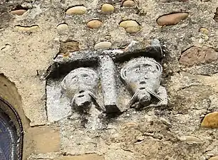 Têtes sculptées sur la façade de l'église.