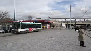 Esplanade devant la gare avec station de tramway de la ligne T1 et arrêt de lignes de bus.