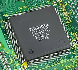 Le controleur T9901 de Toshiba. Ce boîtier de circuit intégré contient en particulier de la mémoire vive, un oscillateur à fréquence variable ou des conducteurs pour les imprimantes et les micros.