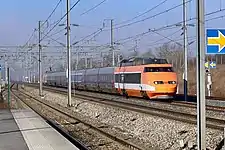 Vue de la rame 01 (en livrée spéciale pour sa tournée avant radiation) traversant la gare de Champagne-Ardenne TGV, sur ses voies centrales sans quai.