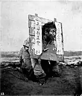Photo prise en 1870 d'un homme puni par une cangue