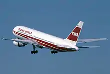 Un avion aux couleurs de la TWA peu après son décollage ; le train d'atterrissage est sorti.