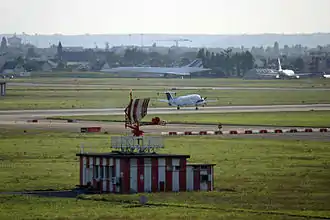 L'ancien radar TA10 de l'aéroport d'Orly, désormais à l'arrêt. Un avion de la Pan Européenne Air Service est en train d'atterrir. Au fond, on peut voir le Concorde et le Mercure du musée Delta.
