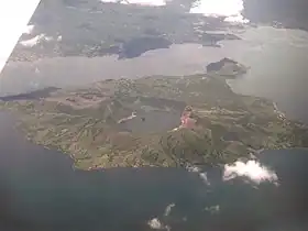 Vue aérienne de Volcano Island entourée par le lac Taal et comportant à son sommet une caldeira partiellement remplie par un lac de cratère.