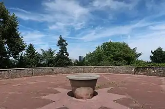 Photographie en couleur d'une petite place avec une table en son centre.