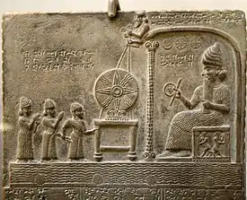 Bas-relief représentant le dieu Shamash faisant face au roi babylonien Nabû-apla-iddina (888-855 av. J.-C.) introduit par un prêtre et une divinité protectrice ; entre les deux, le disque solaire symbolisant le dieuWoods 2004. British Museum.