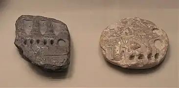 Deux petites tablettes avec des impressions et des signes ronds et linéaires.