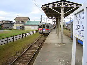 Photo couleur d'un quai de gare avec un train arrivant