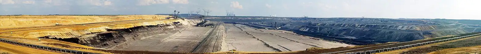 Production d'énergie fossile à partir de lignite dans le Bassin rhénan ; au premier plan la mine de lignite à ciel ouvert de Garzweiler et à l'arrière-plan des centrales au lignite et des lignes à haute tension.