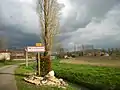 Panneau d'entrée du village avec à gauche l'eau d'un ruisseau dévié de la Garonne, les villageois l'appelle Garonnette