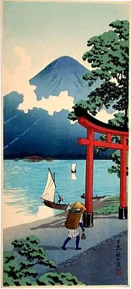 Estampe en couleur montrant une montagne au bord d'un lac sur lequel navigue deux bateaux à voiles. Un portique de sanctuaire shinto et un homme, de dos, en habits traditionnels, au premier plan.