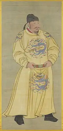 Peinture d'un homme d'âge moyen barbu, asiatique, debout dans une robe jaune décorée de dragons
