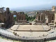 Vue d'ensemble sur le théâtre depuis le haut des gradins, avec la brèche sur la Méditerranée.