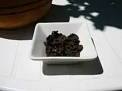 De la tapenade dans un ramequin blanc et carré