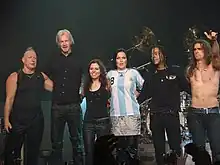 Six membres d'un groupe saluant après un concert