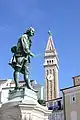 Le monument à Tartini et en arrière-plan le campanile de l'église Saint-Georges (sl).