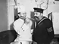 Le cuisinier du navire donne à un marin un avant-goût du Christmas pudding de 1940 à terre à HMS Cochrane (novembre 1940).