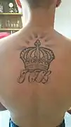 Tatouage symbolique représentant une couronne ornée d'un lettrage.