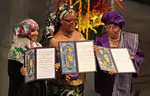 Photo de trois femmes tenant leur diplôme du prix Nobel durant la cérémonie.
