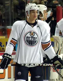 Photographie couleur de Taylor Hall sur la glace portant le maillot blanc des Oilers d'Edmonton