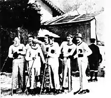 Photographie en noir et blanc de joueurs de hockey sur glace vêtus de blanc.