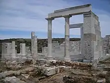 photographie : un petit temple gris en ruines avec colonnes et architrave