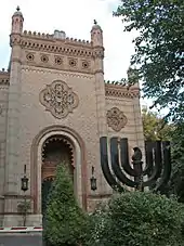 La synagogue chorale avec devant le monument aux morts de la Shoah.