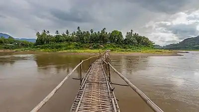 Vue de face d'une passerelle (architecture) en bois au-dessus de la rivière Nam Khan, conduisant vers Luang Prabang, durant la mousson. Juin 2018.