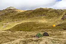 Photo de deux tentes dans un paysage de haute montagne.