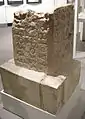 Inscription épigraphique gravée sur la stèle du Lapis Niger ouvragée dans de la pierre de tuf et signifiant le terme étrusque à syntaxe latine : « Regei » (« au roi ». Épigraphie qui se lit de bas en haut et de droite à gauche en caractère étrusque,,,,,,, :