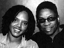 photo noir et blanc de deux Noir-Américains, une femmes aux cheveux crépus et un homme avec des lunettes de soleil