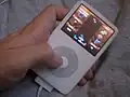 Photo d'un iPod, avec le jeu Tetris à l'écran, et d'une main sur la zone de contrôle de l'appareil.